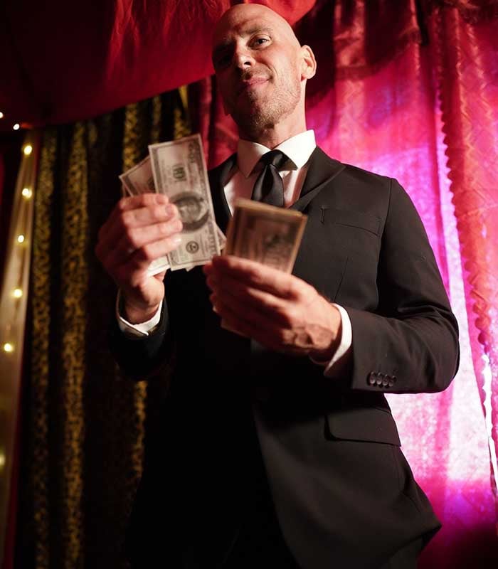 Johnny Sins wearing fitting suit and counting money.